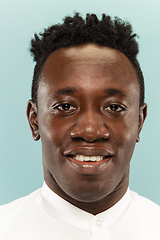 Image showing African-american young man\'s close up portrait on blue background