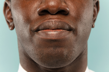 Image showing African-american young man\'s close up portrait on blue background