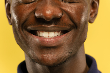 Image showing African-american young man\'s close up portrait on yellow background