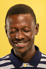 Image showing African-american young man\'s close up portrait on yellow background