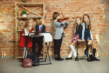 Image showing Group of kids spending time after school together. Handsome friends resting after classes.