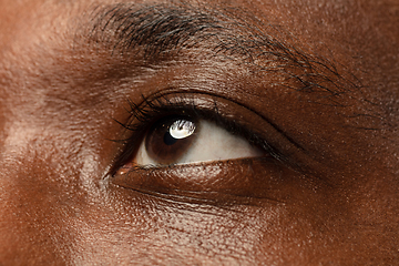 Image showing African-american young man\'s close up portrait on blue background