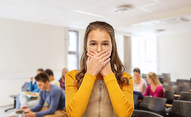 Image showing scared student girl closing mouth at school