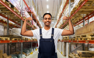 Image showing happy indian worker showing his power at warehouse