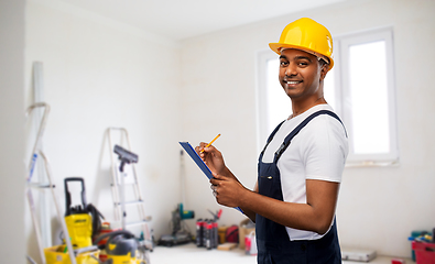 Image showing happy builder in helmet with clipboard and pencil