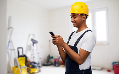 Image showing happy indian or builder in helmet using smartphone