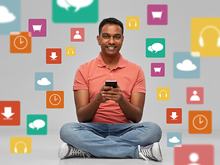 Image showing happy indian man using smartphone over app icons