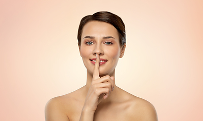 Image showing beautiful young woman holding finger on lips