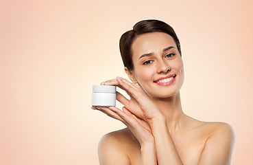 Image showing happy young woman holding jar of cream