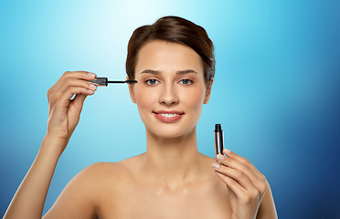 Image showing beautiful woman applying mascara