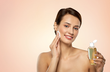 Image showing young woman with toner or cleanser and cotton pad