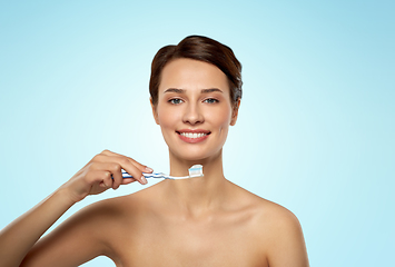 Image showing smiling woman with toothbrush cleaning teeth