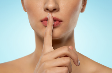 Image showing beautiful young woman holding finger on lips