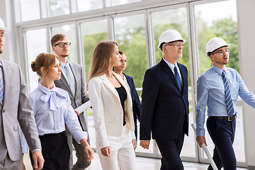 Image showing business team in helmets walking along office