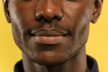 Image showing African-american young man\'s close up portrait on yellow background