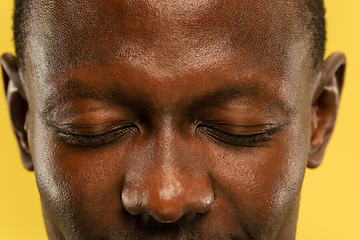 Image showing African-american young man\'s close up portrait on yellow background