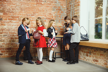 Image showing Group of kids spending time after school together. Handsome friends resting after classes.