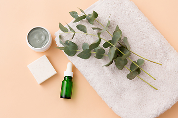 Image showing serum, clay mask, oil and eucalyptus on bath towel