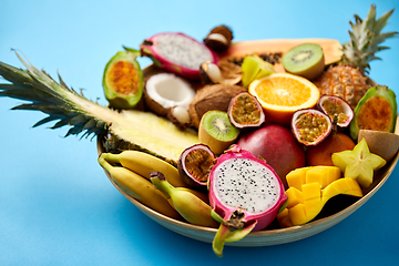 Image showing plate of exotic fruits on blue background