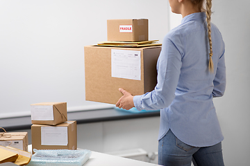 Image showing woman walking with parcels at post office