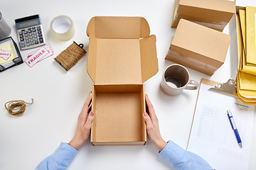 Image showing hands with empty parcel box and mug at post office