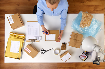 Image showing close up of woman filling postal form at office