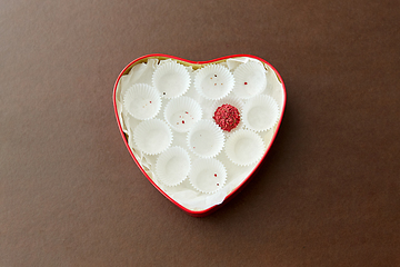 Image showing one candy in red heart shaped chocolate box