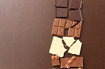 Image showing different kinds of chocolate on brown background