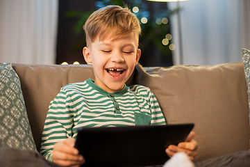 Image showing happy little boy with tablet computer at home