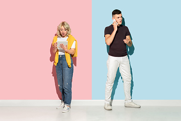 Image showing Young emotional man and woman on pink and blue background