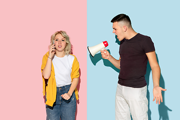 Image showing Young emotional man and woman on pink and blue background