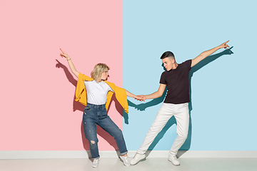 Image showing Young emotional man and woman on pink and blue background