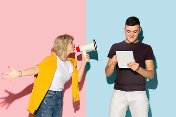 Image showing Young emotional man and woman on pink and blue background