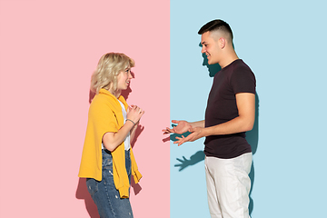 Image showing Young emotional man and woman on pink and blue background