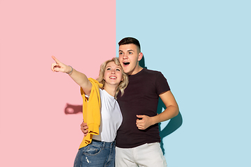 Image showing Young emotional man and woman on pink and blue background