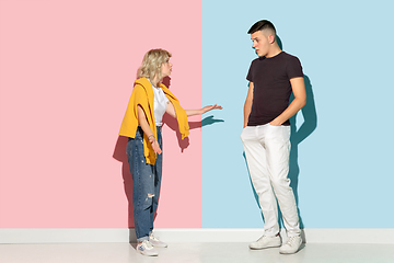 Image showing Young emotional man and woman on pink and blue background