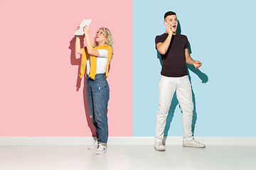 Image showing Young emotional man and woman on pink and blue background