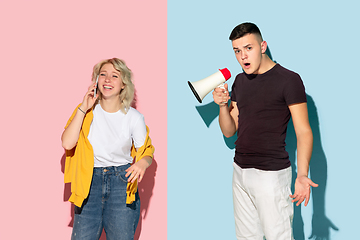 Image showing Young emotional man and woman on pink and blue background