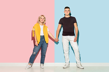 Image showing Young emotional man and woman on pink and blue background