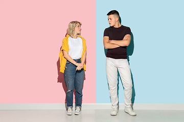 Image showing Young emotional man and woman on pink and blue background