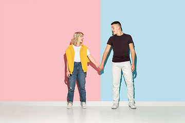 Image showing Young emotional man and woman on pink and blue background