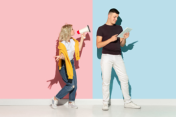 Image showing Young emotional man and woman on pink and blue background