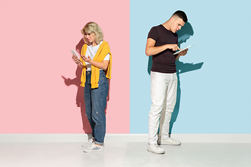 Image showing Young emotional man and woman on pink and blue background