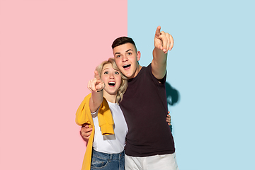 Image showing Young emotional man and woman on pink and blue background