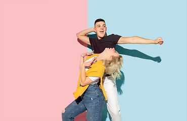 Image showing Young emotional man and woman on pink and blue background