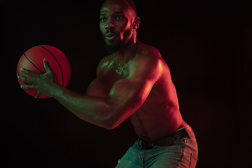 Image showing Young african-american basketball player against dark background