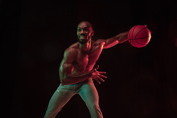 Image showing Young african-american basketball player against dark background