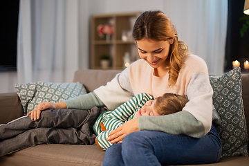 Image showing happy mother with sleeping little son at home