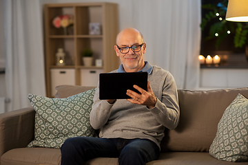 Image showing happy senior man with tablet computer at home