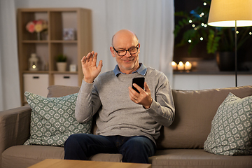 Image showing old man with smartphone having video call at home